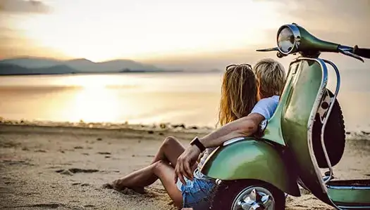 Renting motos para particulares en Menorca. Una pareja de la playa en la Isla